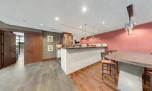 巴尔的摩Delta Hotels by Marriott Baltimore North的粉红色墙壁的厨房和带椅子的酒吧