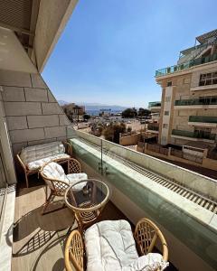 埃拉特Sea side 87 Sweet Me Eilat אילת的大楼内的阳台配有椅子和床