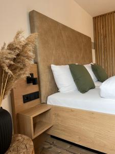 蒂蒂湖-新城MINAROSO appartements am badeparadies -ehemalig Kaltenbachs Appartements的一间卧室配有一张带白色和绿色枕头的床