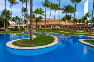 科曼达图巴岛Transamerica Comandatuba - All Inclusive Resort的度假村前的棕榈树游泳池