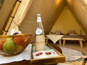 欧拉Husaak Glamping的帐篷内的桌子上坐着一瓶酒