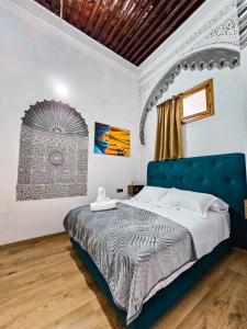 拉巴特DAR SABA的一间卧室配有一张大床和蓝色床头板
