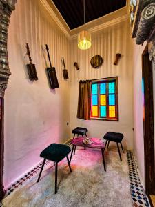 拉巴特DAR SABA的客房设有桌子、两把椅子和窗户。