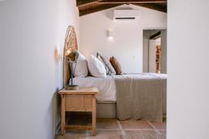 蒙达San Roque Suites de Monda的一间卧室配有一张床和一张桌子上的台灯
