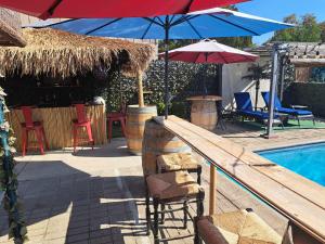 弗雷斯诺Tropical Paradise的游泳池旁的游泳池配有椅子和遮阳伞