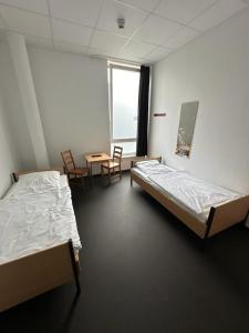 汉堡Arena Hostel & Monteurzimmer的一间设有两张床和一张桌子及椅子的房间
