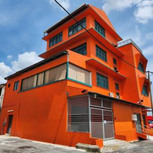 怡保Ipoh town centre glamping home 13pax的一座橙色的建筑,有很多窗户