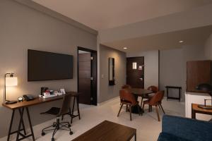 蓬塔卡纳福朋喜来登蓬塔卡纳村酒店的客厅配有电视和桌椅