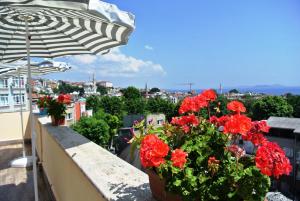 伊斯坦布尔福尔酒店的阳台上的红花盆,带雨伞