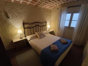 佩拉托拉达Casa Peratallada的一间卧室配有一张大床和两条毛巾