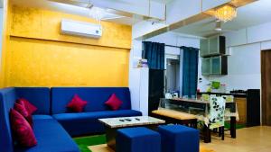 卡兰古特Luxurious Spacious 2 BHK With Pool Wi-Fi Cooking Gas Gym的客厅配有蓝色的沙发和桌子