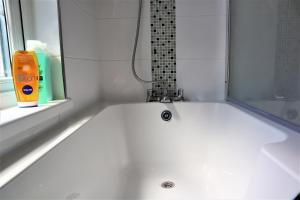 北安普敦Victoria 4 bedroom Serviced House Short Lets - Near Northampton Gen Hosp & Town Centre的带窗户的浴室内的白色浴缸