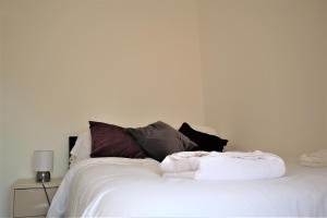 北安普敦Victoria 4 bedroom Serviced House Short Lets - Near Northampton Gen Hosp & Town Centre的一张白色的床,上面有一堆枕头