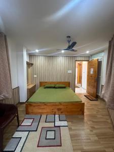 达兰萨拉Dhauladhar Homes的一间卧室,卧室内设有一张绿色大床