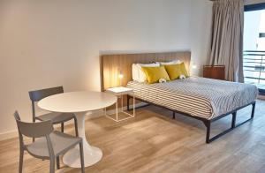 布宜诺斯艾利斯Babel Botánico的酒店客房带一张床、一张桌子和椅子