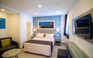 博德鲁姆Queen Victoria Suit Apart OTEL的一间卧室配有一张床、一张沙发和一台电视。