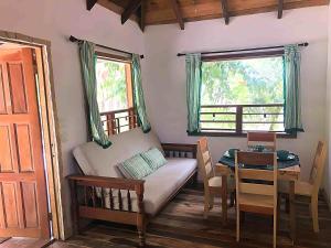玛雅湾Kin Resort Lodge的客房设有床、桌子和窗户。