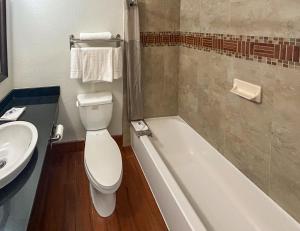 安大略加利福尼亚安大略6号汽车旅馆的浴室配有卫生间、盥洗盆和浴缸。