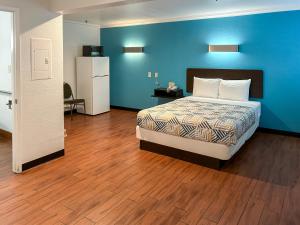 安大略加利福尼亚安大略6号汽车旅馆的一间卧室设有一张床和蓝色的墙壁