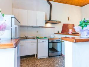 NibbiaiaApartment Podere La Madonnina-1 by Interhome的厨房配有白色橱柜和炉灶烤箱。
