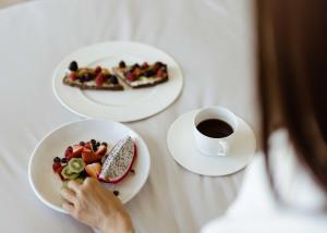 斯科茨W斯科茨代尔酒店的坐在桌子上,拿着盘子和咖啡的女人