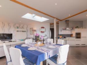 KergadorHoliday Home Maison de Plain Pied - Vue Mer - TRP106 by Interhome的一间配备有蓝桌和白色椅子的用餐室