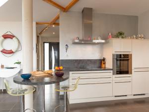 KergadorHoliday Home Maison de Plain Pied - Vue Mer - TRP106 by Interhome的厨房配有白色橱柜和桌椅