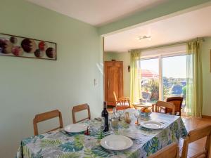 克洛阿尔卡尔诺厄Holiday Home Tal ar Mor - LPU100 by Interhome的餐桌,配有盘子和一瓶葡萄酒