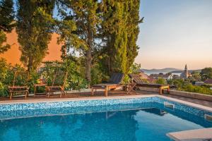 斯拉诺Villa Stella Adriatica的一个带椅子的游泳池,享有城市美景