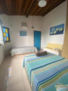 阿拉夏奇巴海滩Pousada Canto do Mar Ilha Grande的卧室配有两张床,地板上铺有条纹毯子。