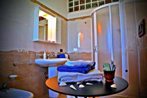 莱切省卡斯特罗B&B L'Orizzonte的一间带水槽和桌子毛巾的浴室