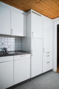 布里格Glishorn Blick的厨房配有白色橱柜和木制天花板