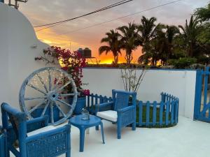 维加伊托Villa Aqua Boutique Vichayito的落日时带蓝色椅子和 ⁇ 轮的庭院