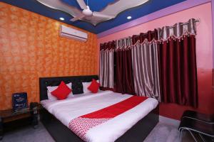 GauripurOYO Hotel Jagannath International Near Kolkata Airport的一间卧室配有红色枕头的床