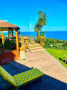 尚克林门托内别墅酒店的坐在靠近大海的砖砌庭院上的黄色长椅