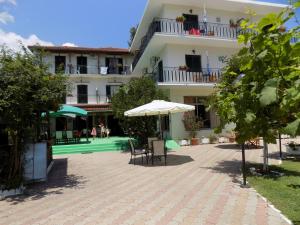 普拉坦亚斯玫瑰公寓式酒店的一座带椅子和遮阳伞的庭院