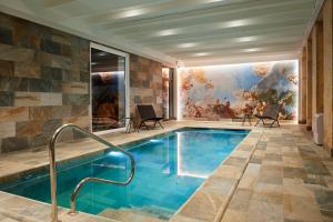 波亚克Best Western Premier Hotel des Vignes et des Anges的墙上画画的房间里的一个游泳池