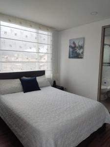 奇亚Hermoso apartamento con estacionamiento gratuito Chía N1的卧室配有一张白色的床和大型床头板