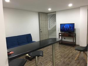 奇亚Hermoso apartamento con estacionamiento gratuito Chía N1的客厅配有蓝色的沙发和电视
