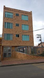 奇亚Espectacular apartamento con estacionamiento gratuito Chía N 2的前面有栅栏的高砖建筑