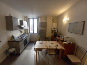 法恩莎Console Camprini Rooms & Apartments的小厨房配有桌子和桌椅