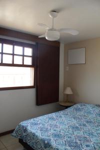 布希奥斯Casa em Búzios com Vista para o Mar的一间卧室配有一张床和吊扇