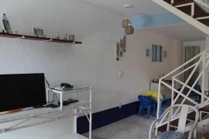 布希奥斯Casa em Búzios com Vista para o Mar的一间带电视和楼梯的客厅