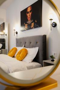 布拉索夫Casa Paul的一间卧室配有一张带黄色枕头和镜子的床