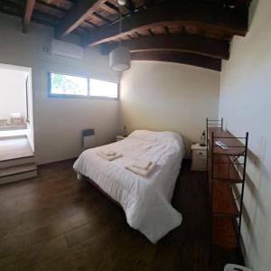 GualeguaychúLa Casa de Bimba的一间卧室配有一张带白色床单的床和一扇窗户。