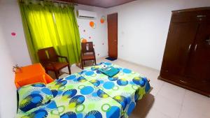 卡塔赫纳Nahimara Champeta Hostel的一间卧室,卧室内配有一张床和椅子