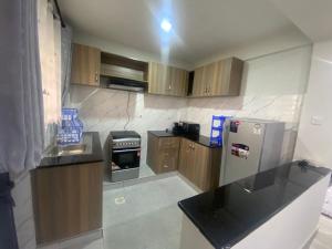 MeruMeru Heights的厨房配有木制橱柜和不锈钢冰箱。