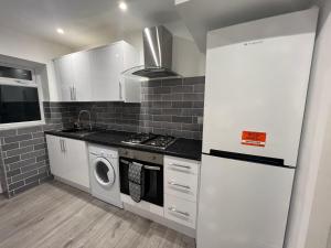 切森特Oakwood Suite - Sleeps 5 - Contractors - Smart TVs in all rooms的厨房配有炉灶、洗衣机和烘干机