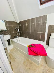 尚克林门托内别墅酒店的浴室设有白色浴缸和粉红色的袋子