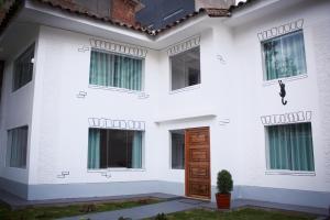 库斯科Casa Alpaca的白色的房子,设有木门和窗户